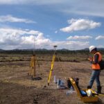 Tim surveyor konstruksi menggunakan drone LiDAR untuk pemetaan lahan 3D dan perencanaan Smart City di area proyek gedung perkotaan.