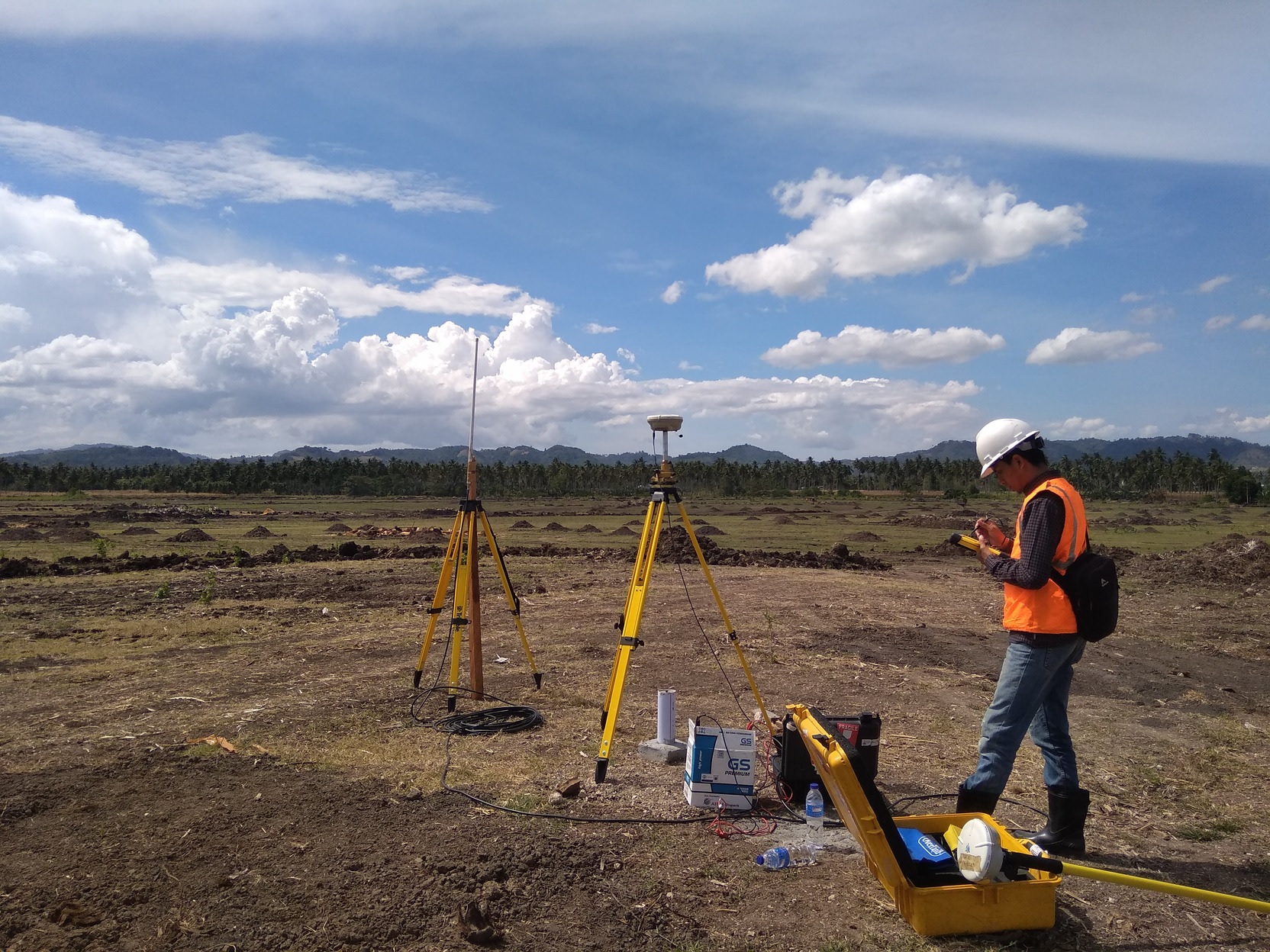 Tim surveyor konstruksi menggunakan drone LiDAR untuk pemetaan lahan 3D dan perencanaan Smart City di area proyek gedung perkotaan.